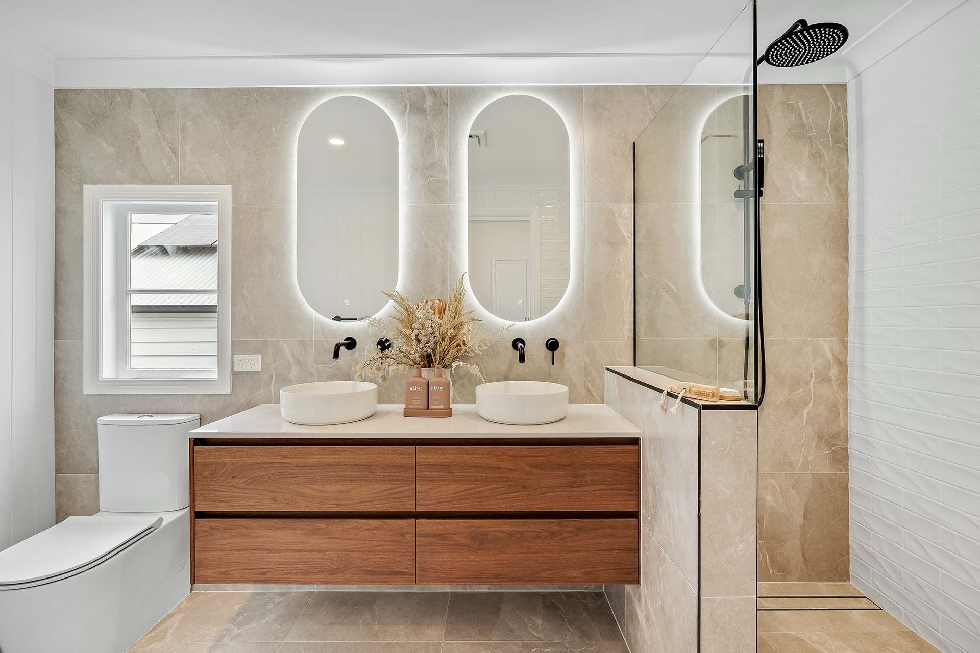 a bathroom with two sinks , a toilet , and a walk in shower .