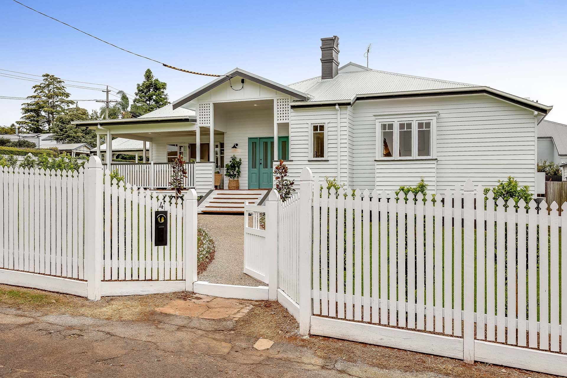 a white house with a white picket fence around it .