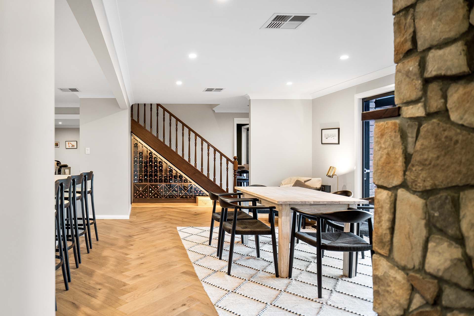 a dining room with a table and chairs and a stone wall .