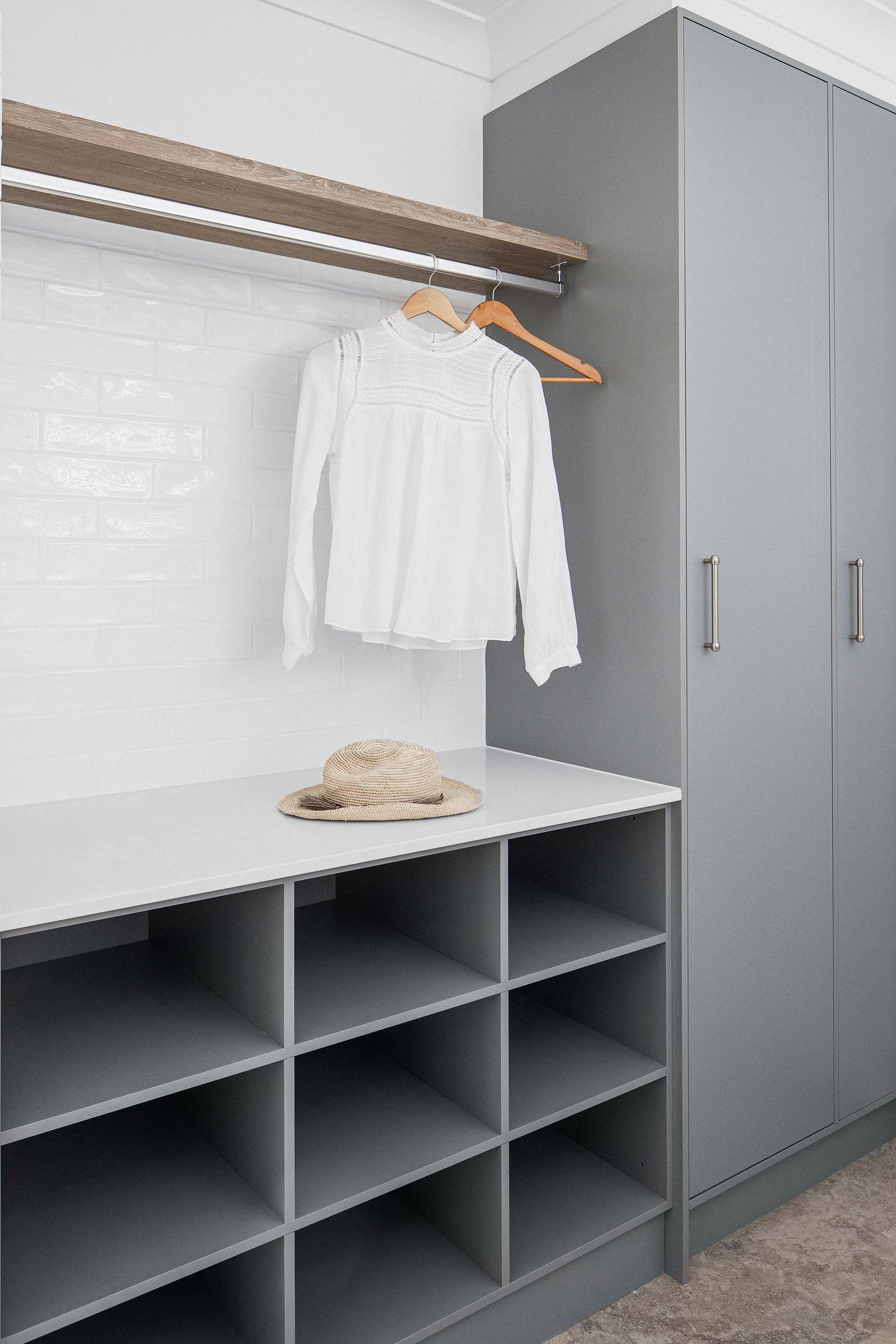 a white shirt is hanging on a rack in a closet .