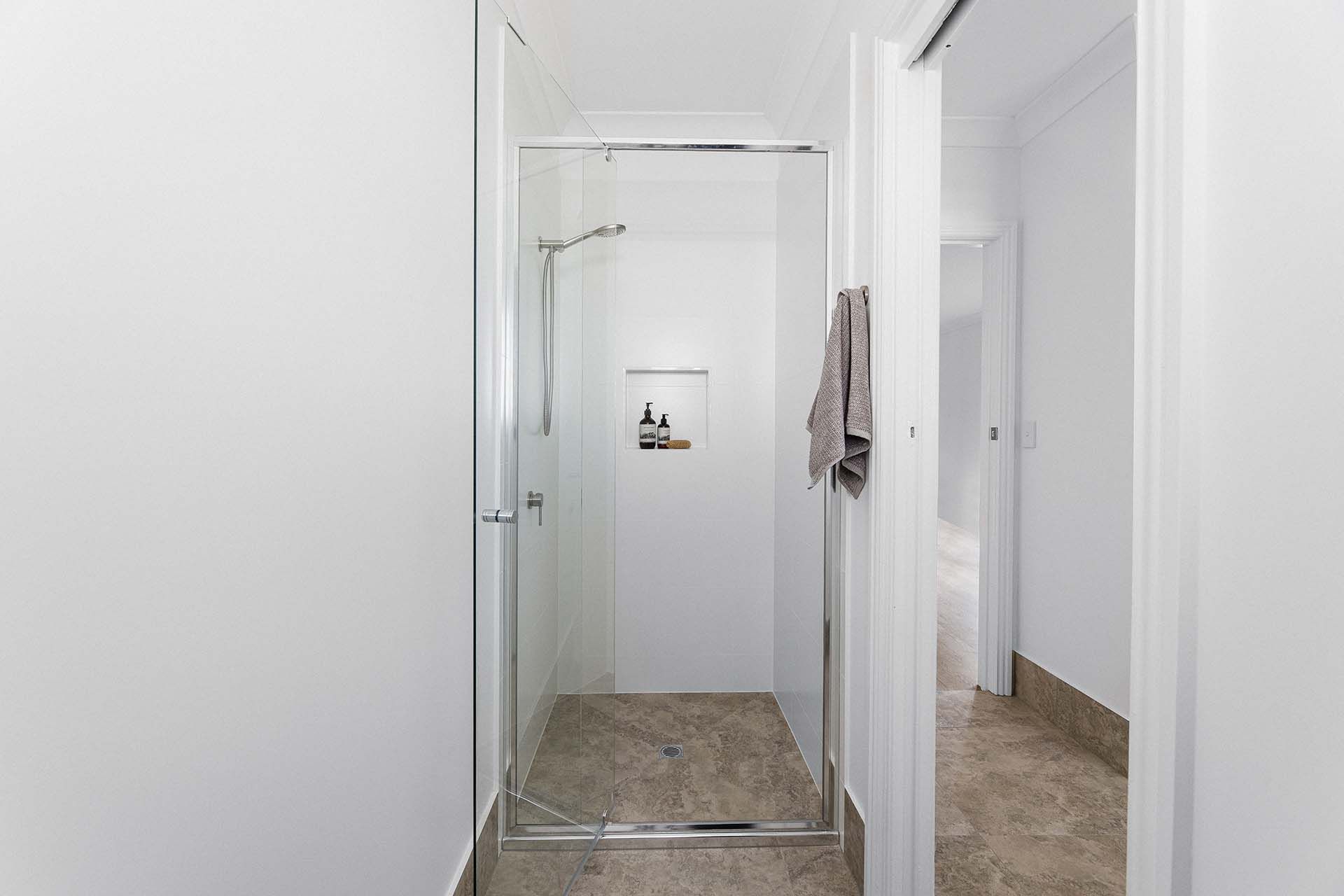 a bathroom with a walk in shower and a towel hanging on the wall .