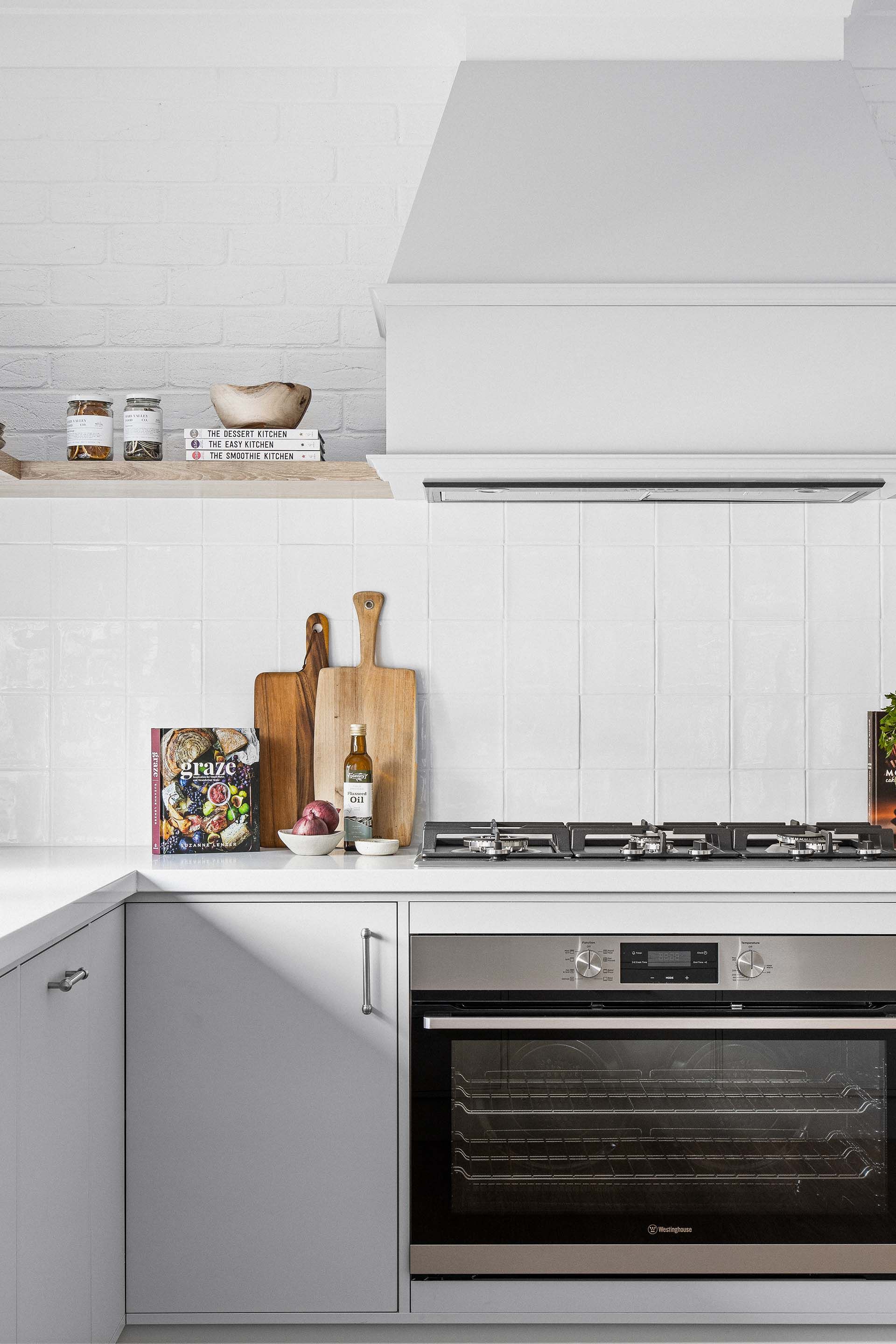 a kitchen with white cabinets and astainless steel oven