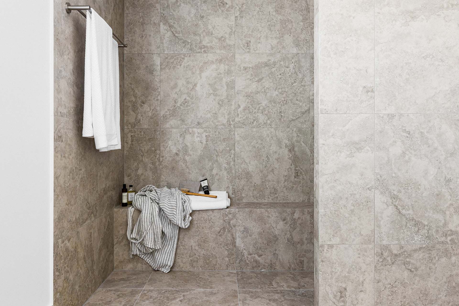 a bathroom with a walk in shower and a towel rack .