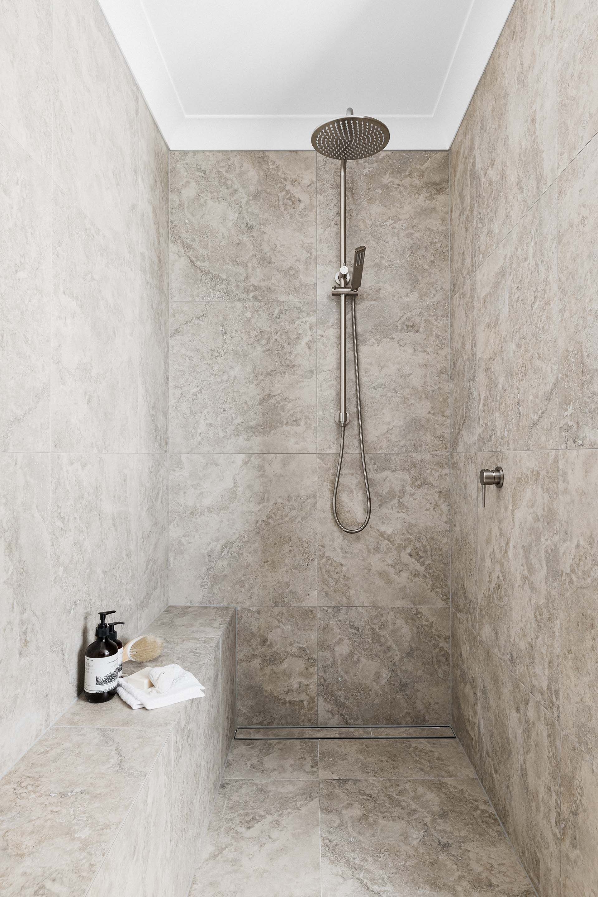 a bathroom with a walk in shower and a bench .