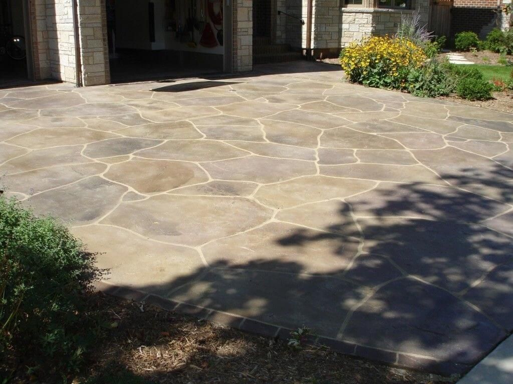 A driveway with a brick building in the background