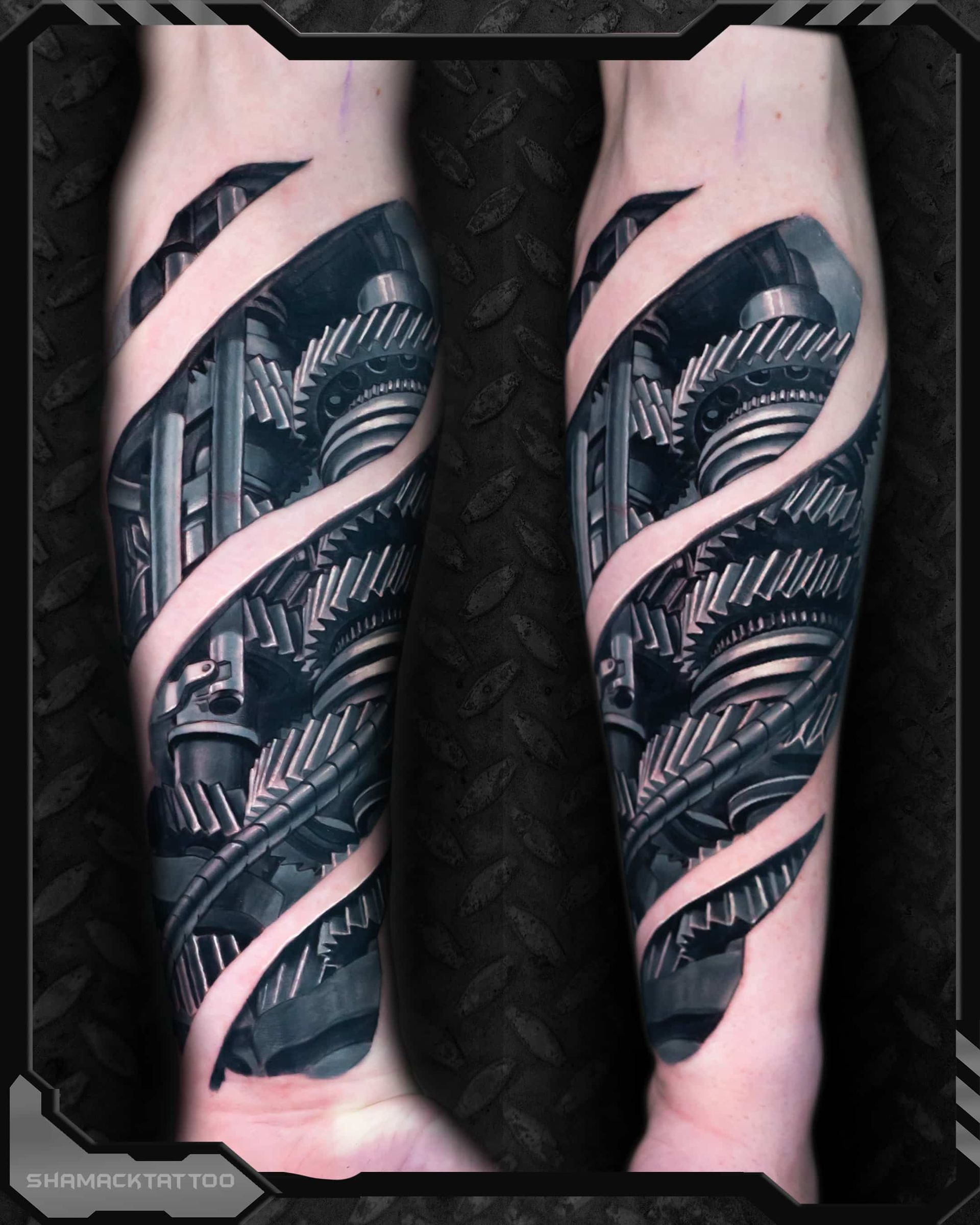 Twin forearms with black-and-gray biomechanical tattoo sleeves wrapped in pink ribbon-like bands