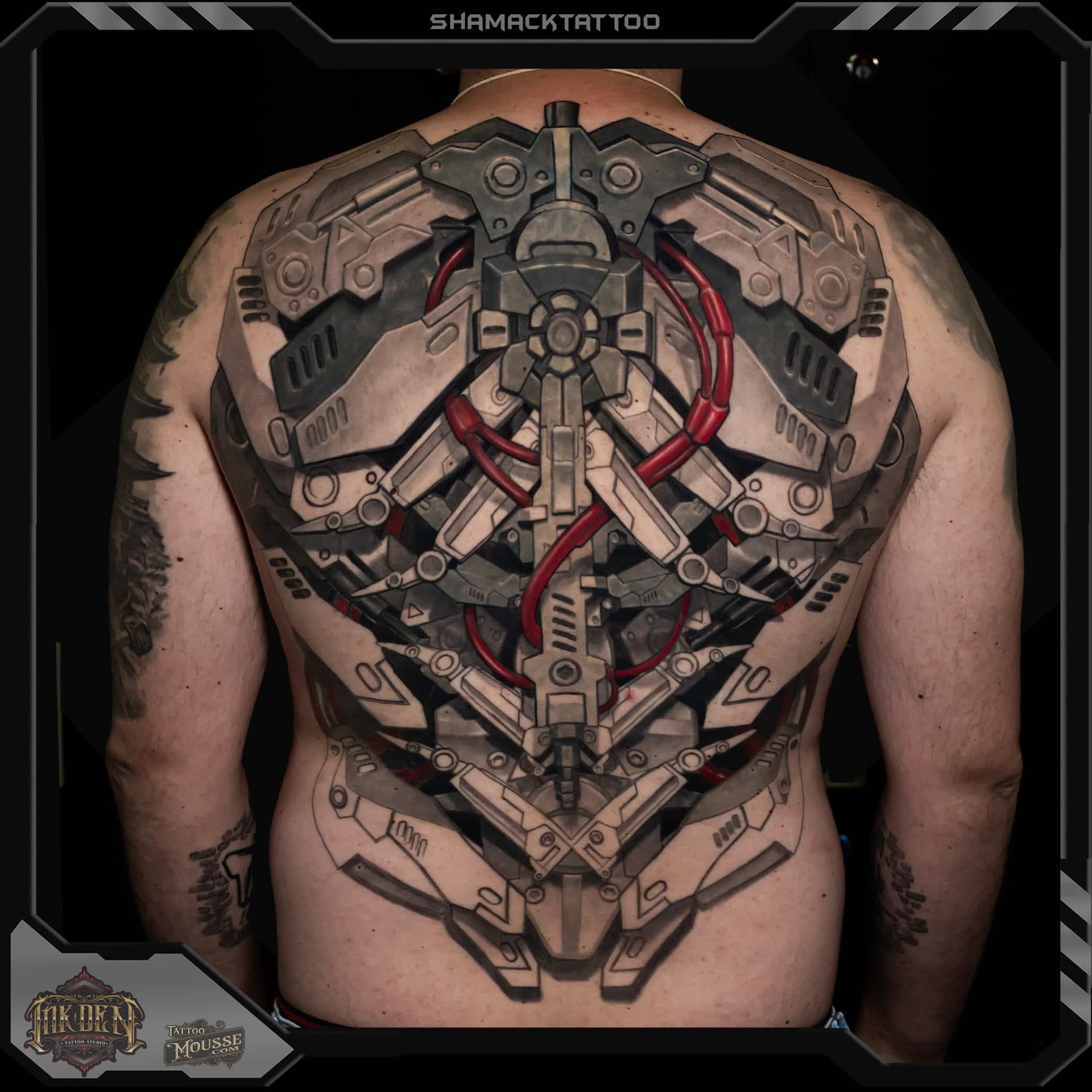 Large mechanical back tattoo with gray and red sci-fi machinery on a person’s bare back