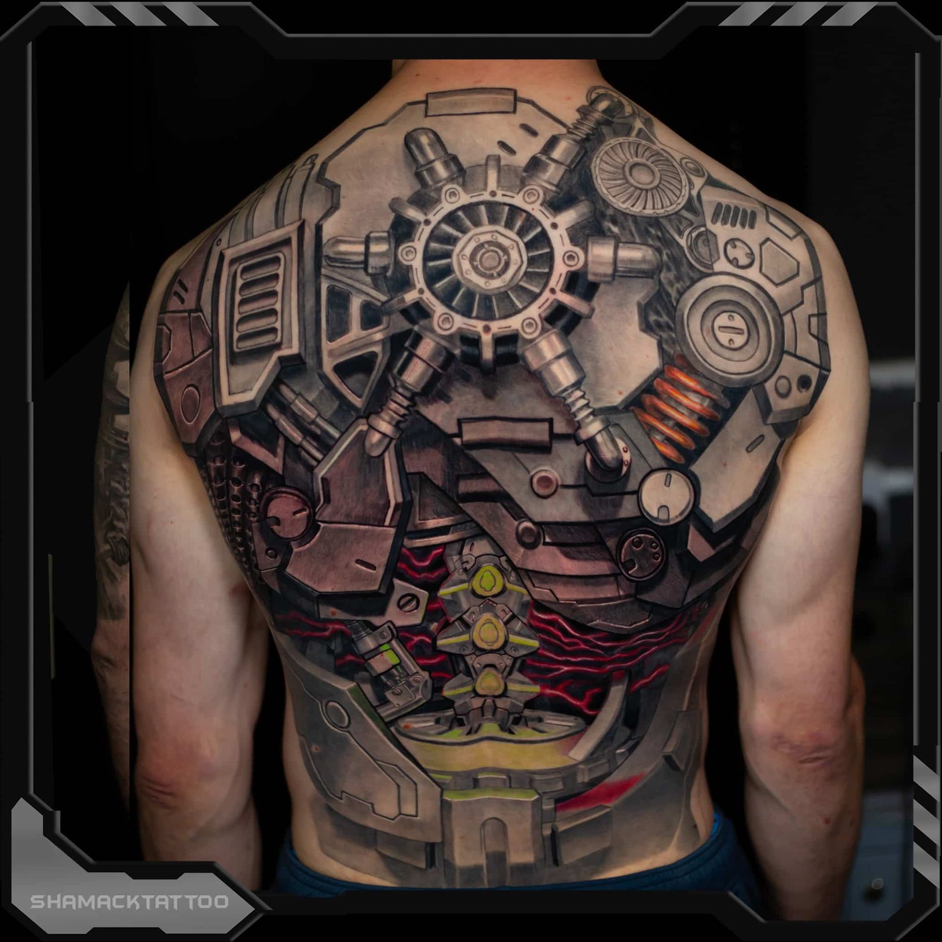 Back tattoo of a steampunk-style mechanical torso with gears, pipes, and red-orange accents