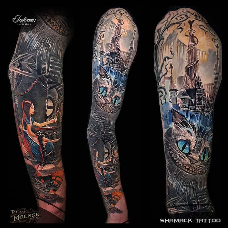Black-and-gray sleeve tattoo with glowing blue cat eyes, gothic scenery, and a seated figure in red-orange accents