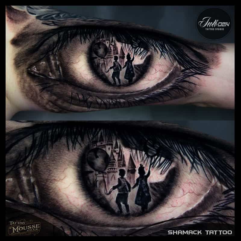 Close-up of a tattooed eye reflecting a child and a castle, shown in two mirrored views.