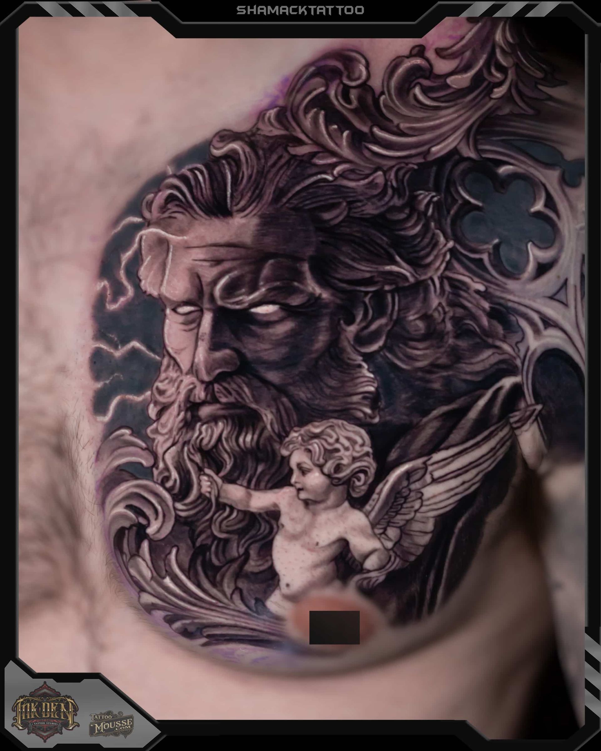Black-and-gray tattoo of a bearded classical face with flowing hair and a small winged cherub on skin