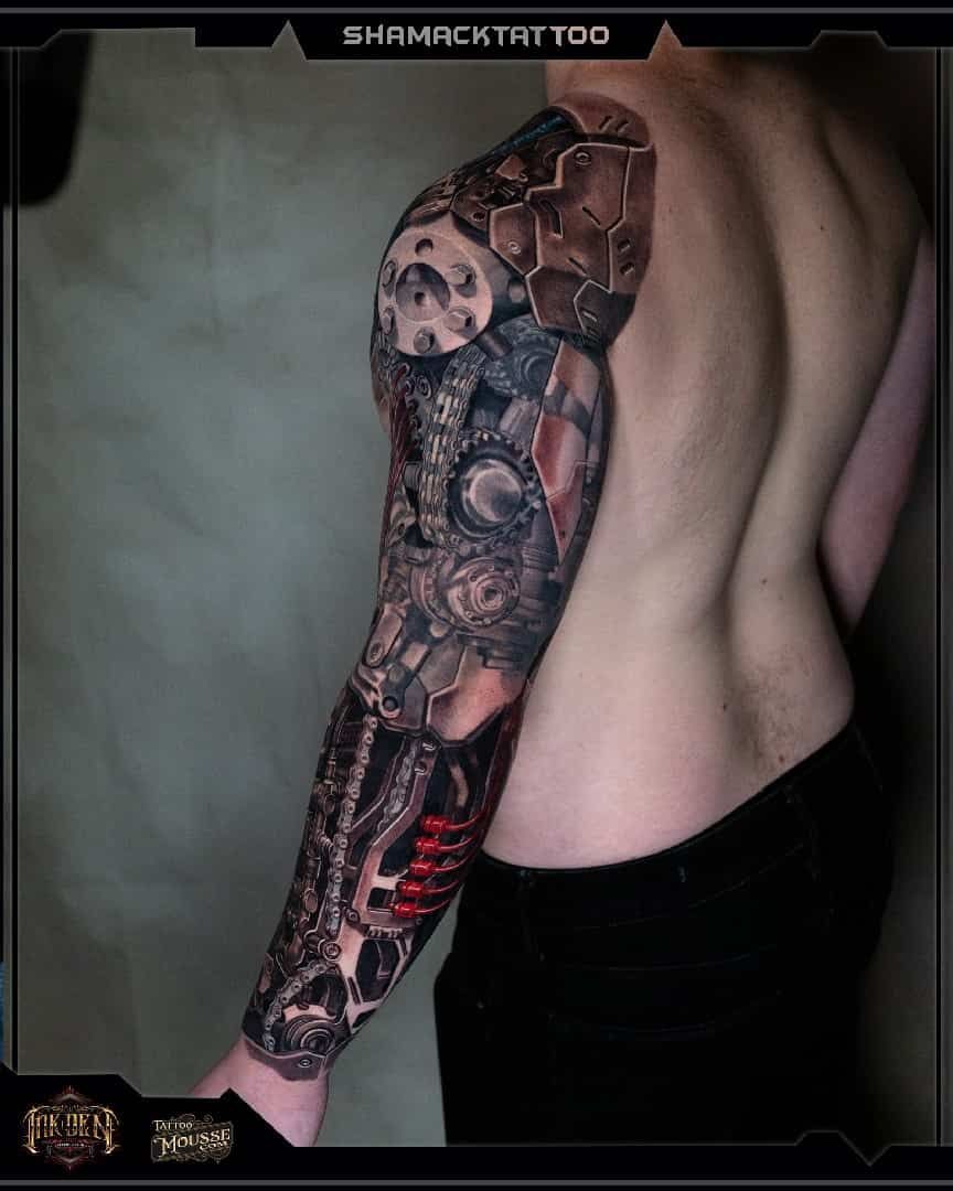 Back tattoo sleeve with skulls and dark red-black shading on a person's side and arm