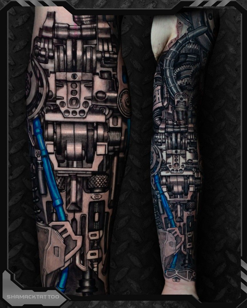 Two legs with full-leg robotic tattoo designs in black, gray, and blue