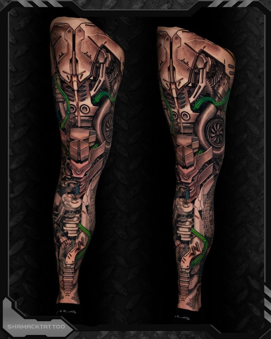 Side-by-side tattooed legs with mechanical, green-accented cyberpunk design on a black background