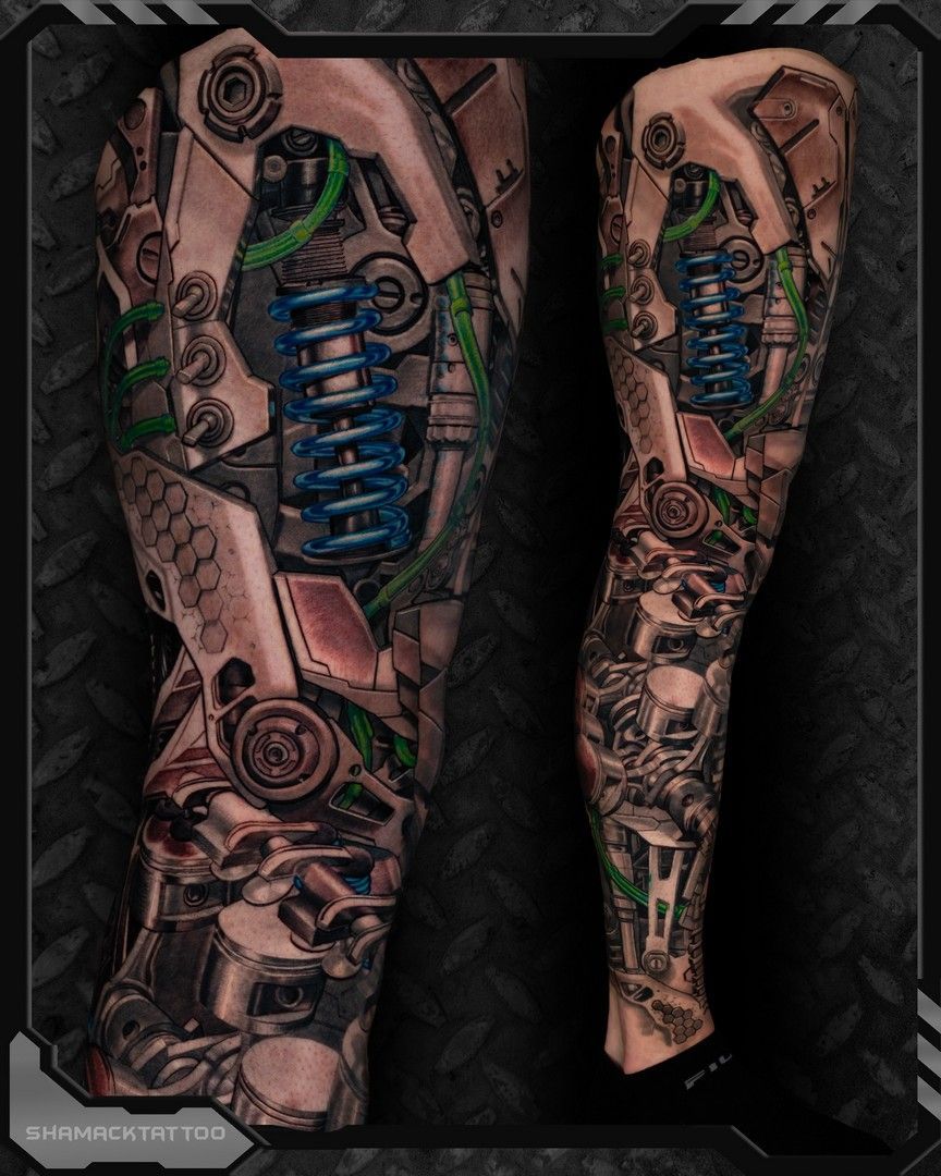 Tattooed legs with steampunk-style blue mechanical designs and gears on a black background