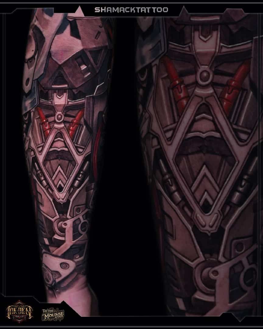 Close-up of a robotic armored leg and torso in dark pink, black, and metallic tones with red glowing details