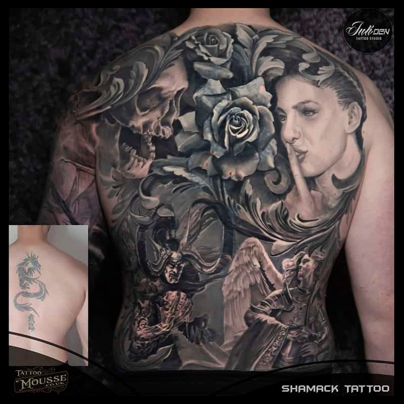 Black-and-gray back tattoo with roses, a woman’s face, and angels in an ornate realistic design