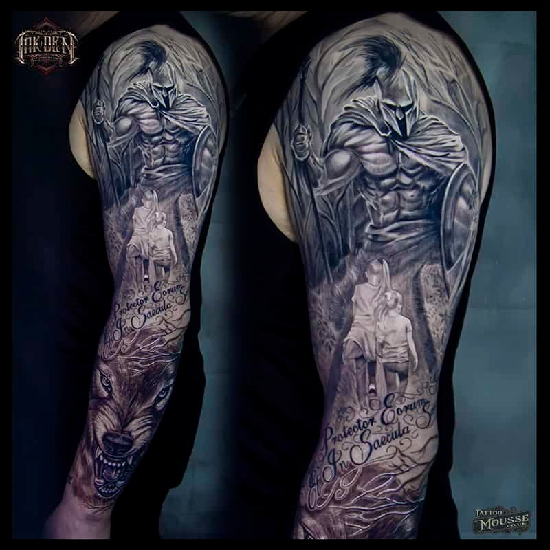 Black-and-gray full-sleeve tattoo on an arm, featuring a hooded angel, roses, and a small child portrait.