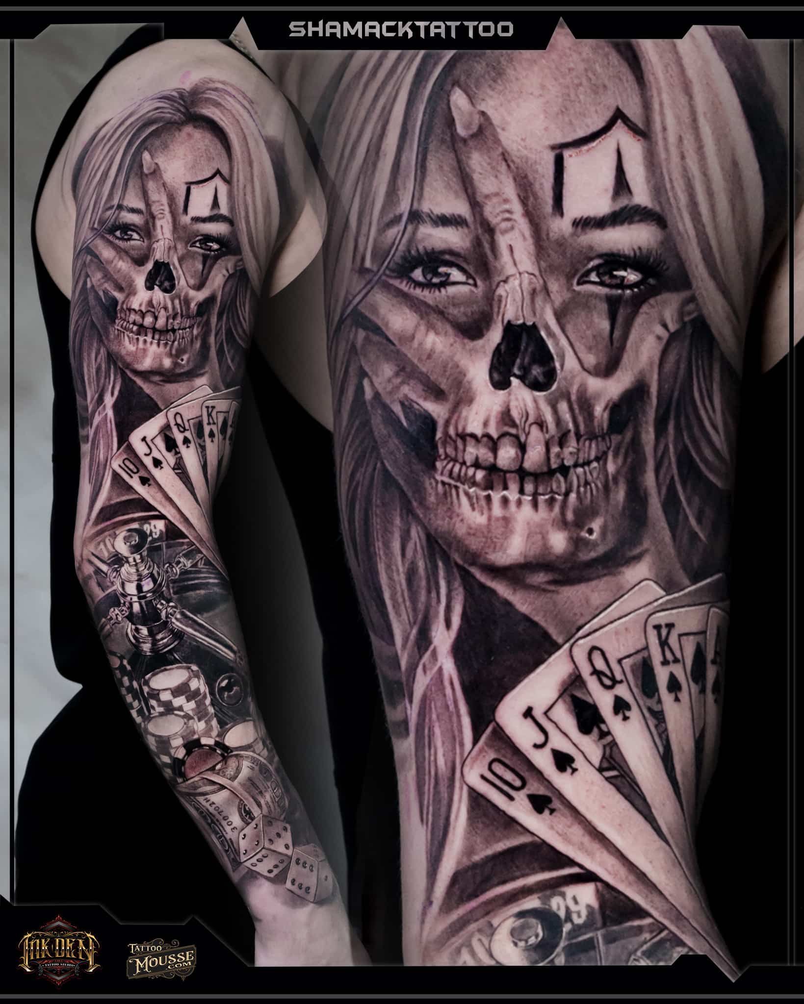 Tattooed arm and back with skull-face portrait and playing cards in grayscale art design