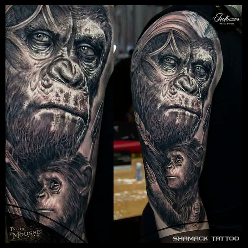 Black-and-gray forearm tattoo of an ape face with a smaller ape face below it