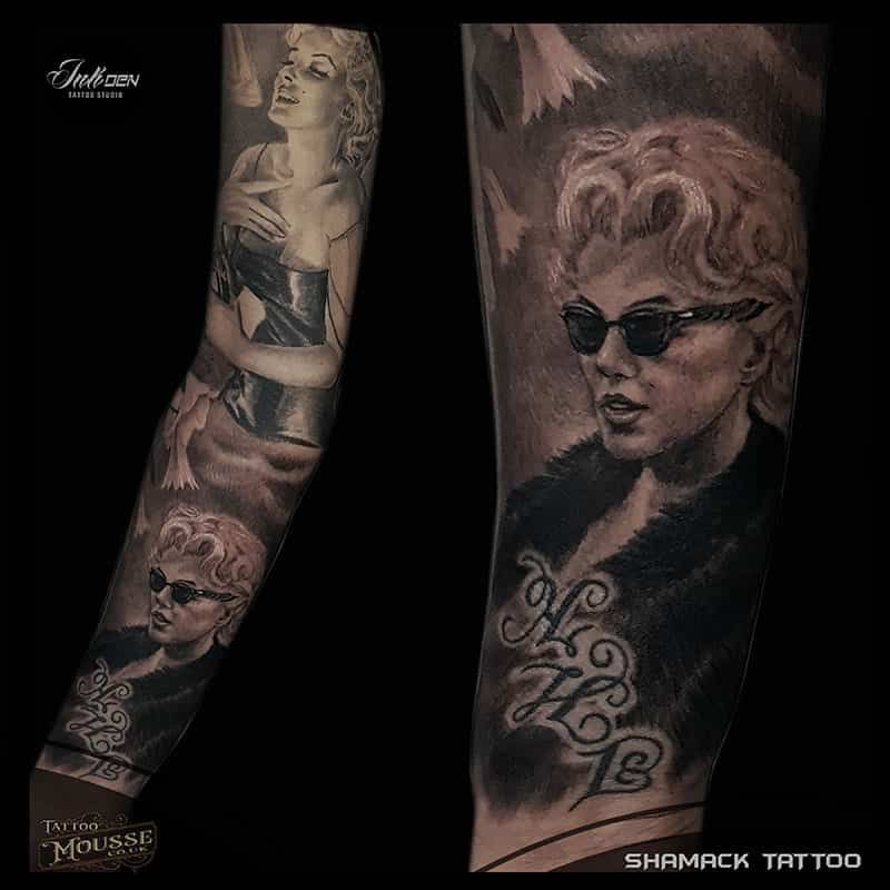 Black-and-gray sleeve tattoo with portraits and vintage-style figures on a forearm