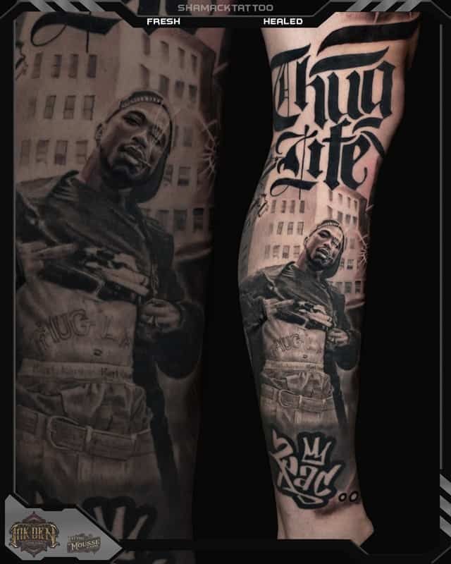 Tattooed forearm with black-and-gray memorial portrait and gothic “Thug Life” lettering
