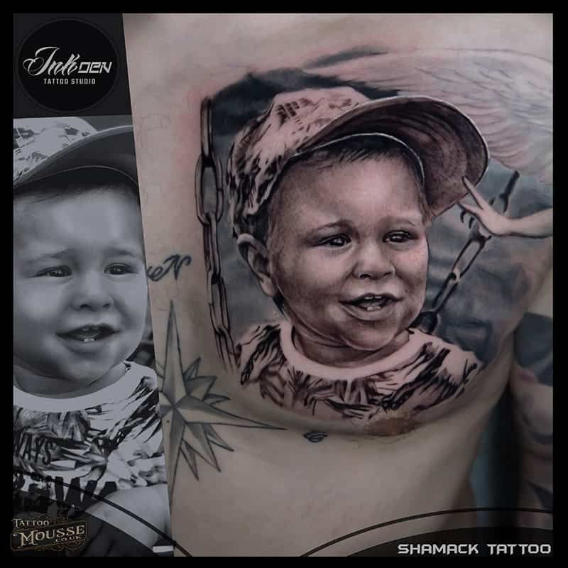 Tattoo portrait of a smiling child in a hat on a person’s upper arm