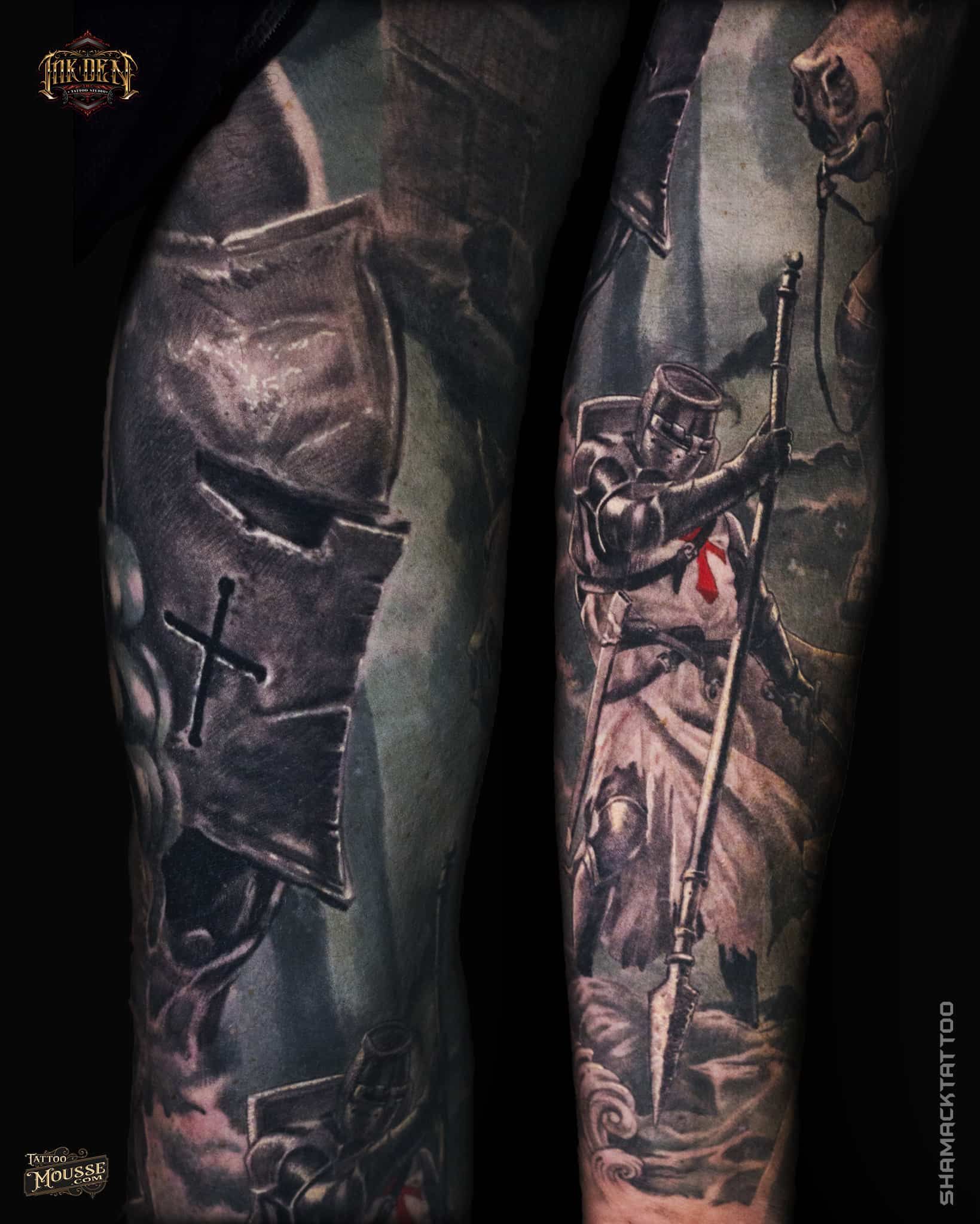 Two tattooed forearms with dark, detailed black-and-gray designs and red accents