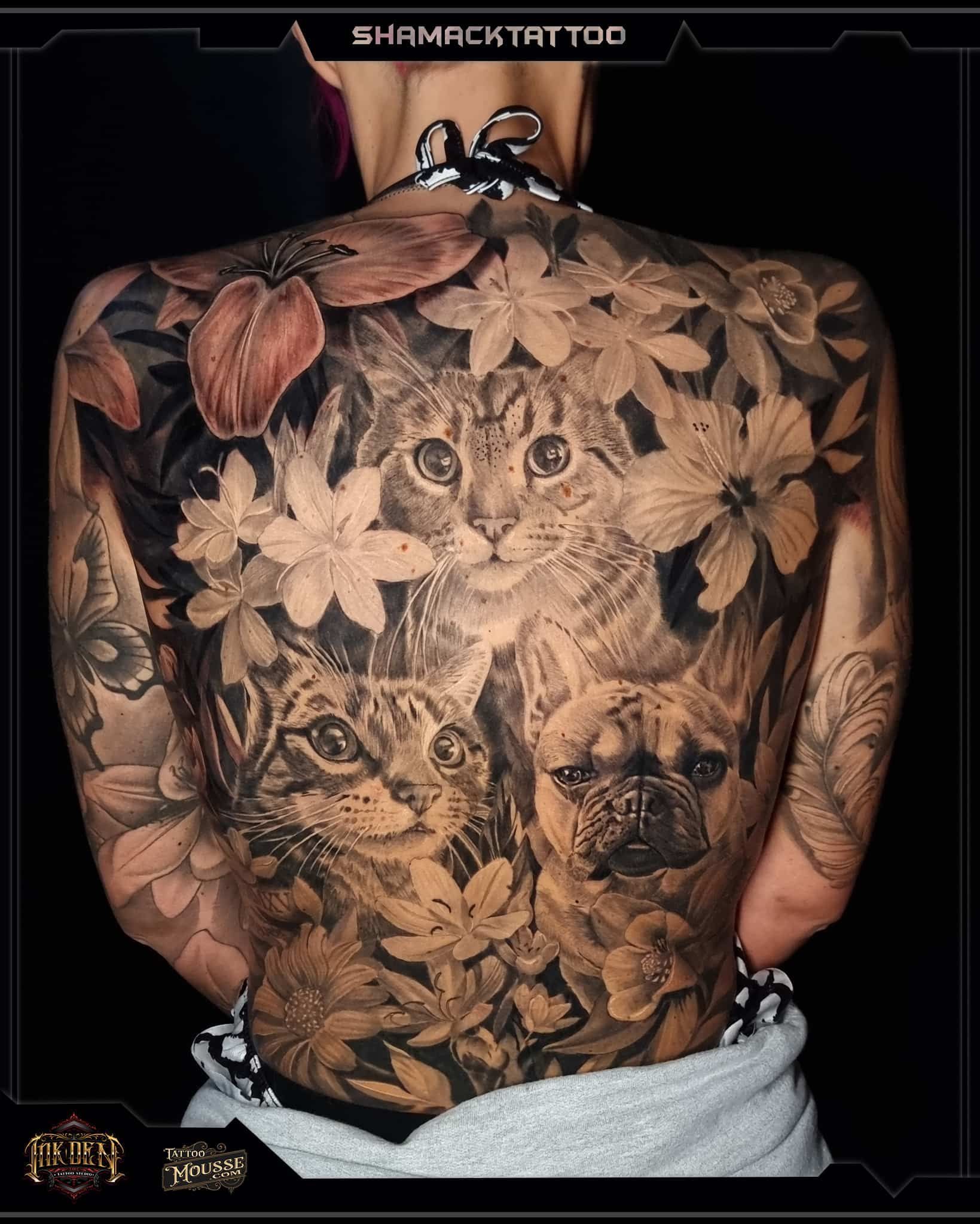 Back view of a person with a large floral animal tattoo across the back and shoulders