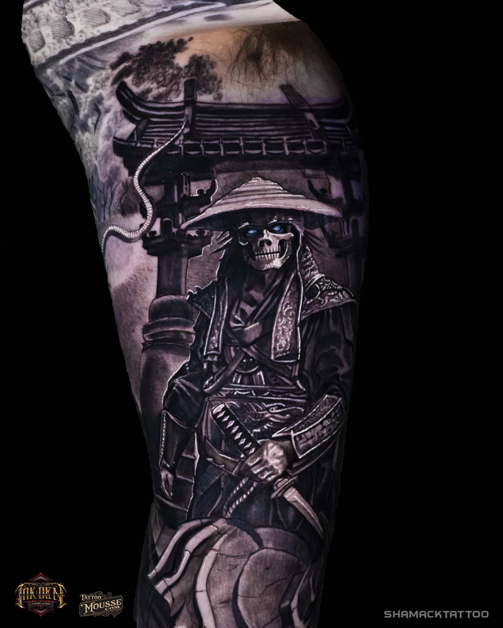 Black-and-gray forearm tattoo of a robed figure seated under an arched structure, with detailed shading.
