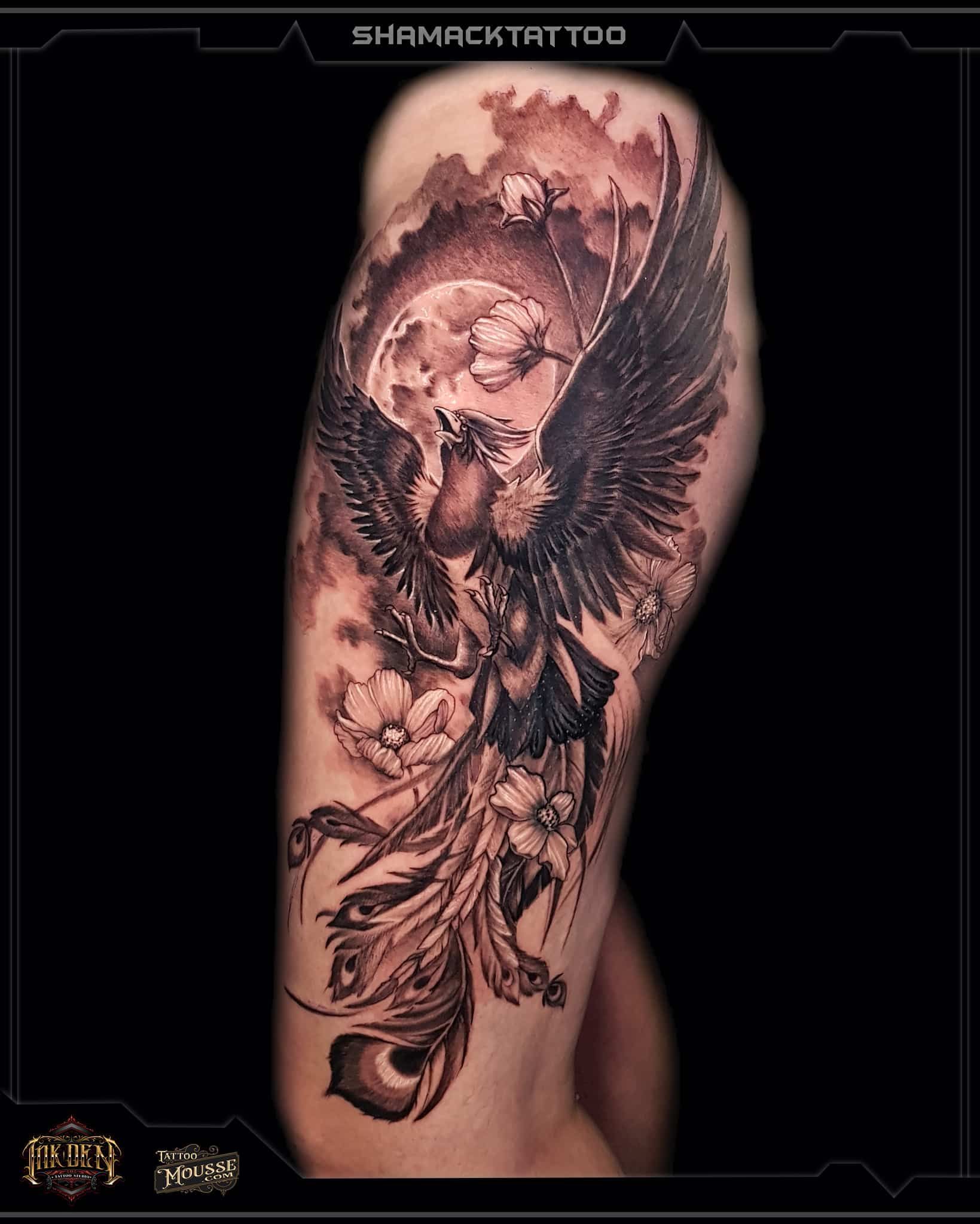 Black-and-gray tattoo of a winged skull and roses on an upper arm