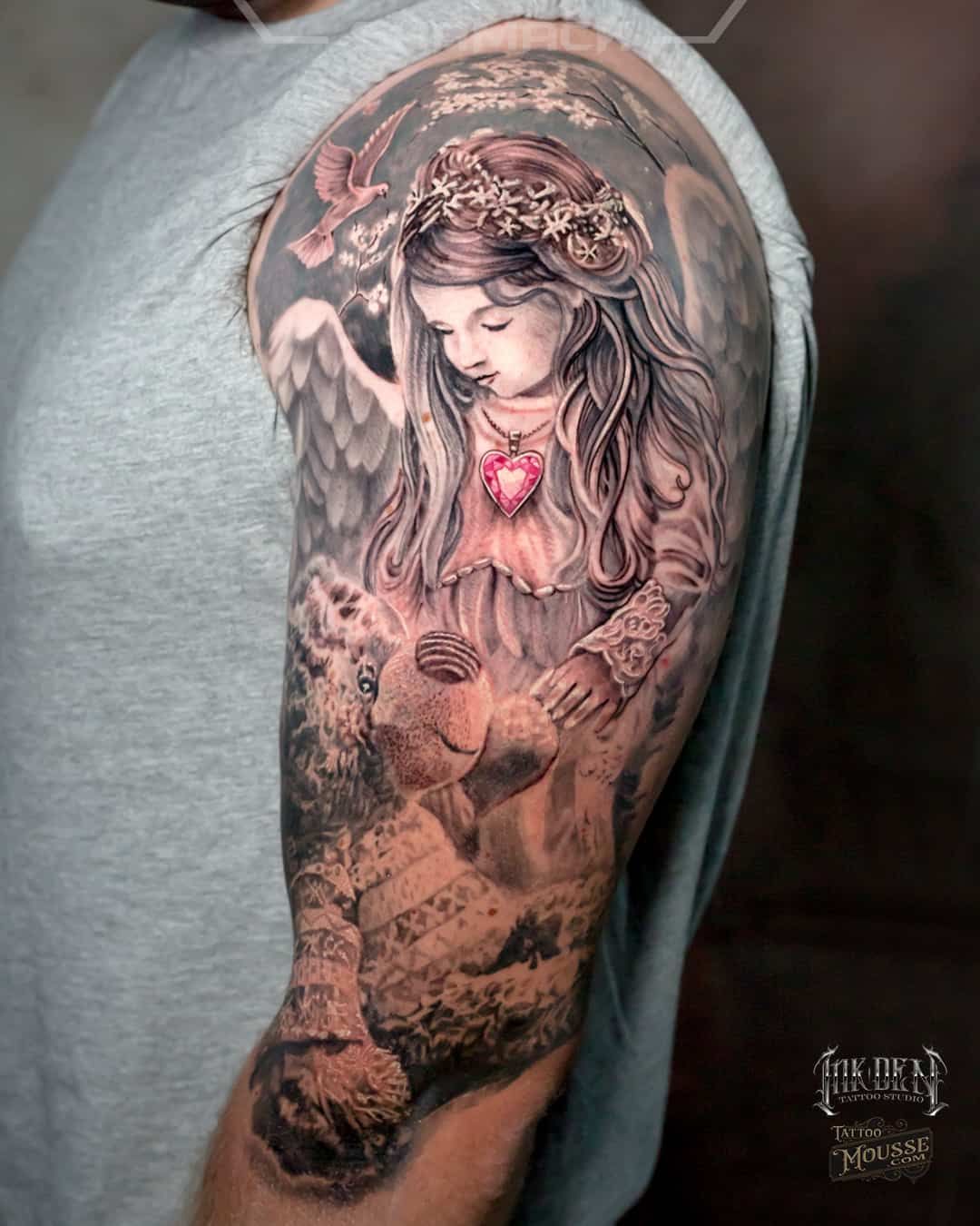 Detailed tattoo of an angelic girl with a glowing heart on a person’s upper arm