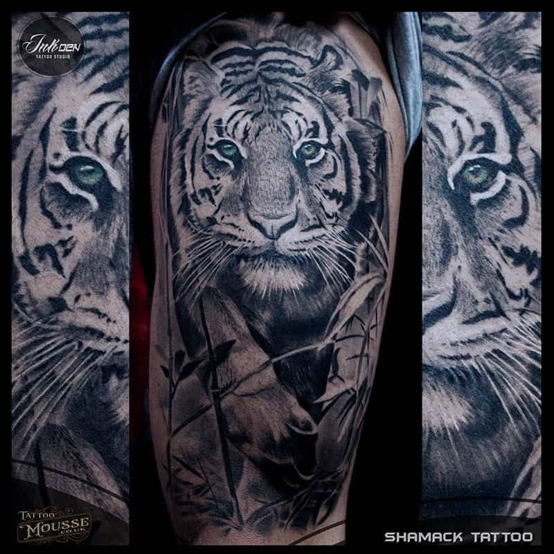 Tiger tattoo on a forearm, with a realistic tiger face and monochrome shading.