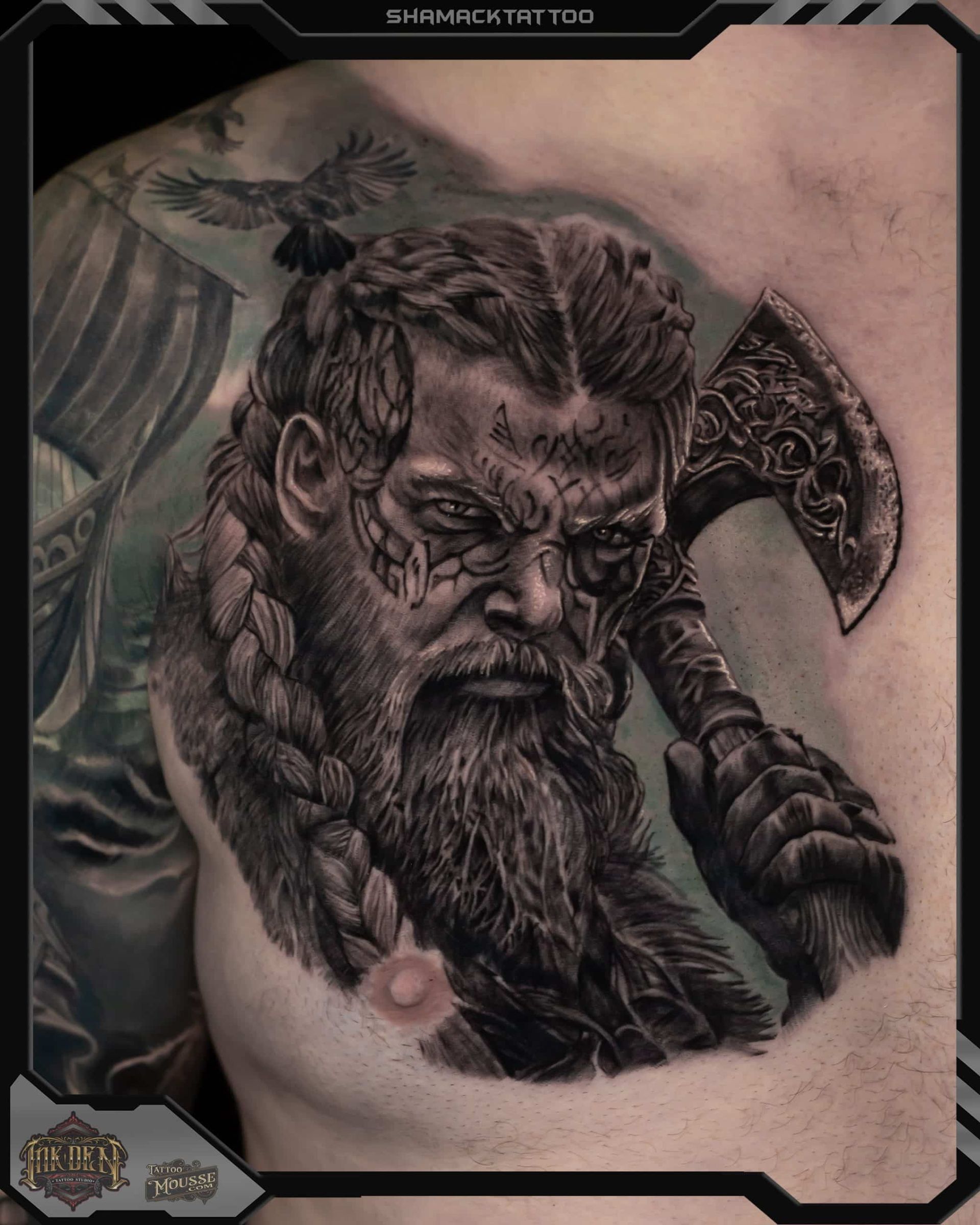 Black-and-gray tattoo of a stern Viking warrior with braided beard, fur cloak, and axe