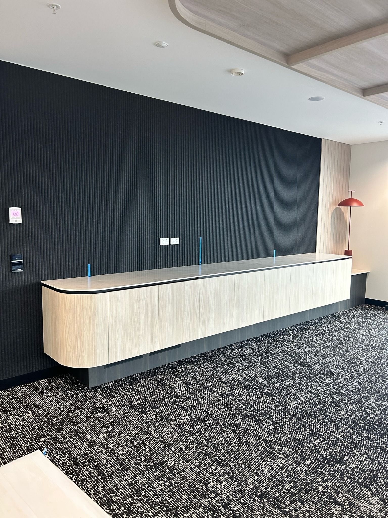 A Long Wooden Counter in a Room With a Black Wall — PKJ Designs in Nowra, NSW