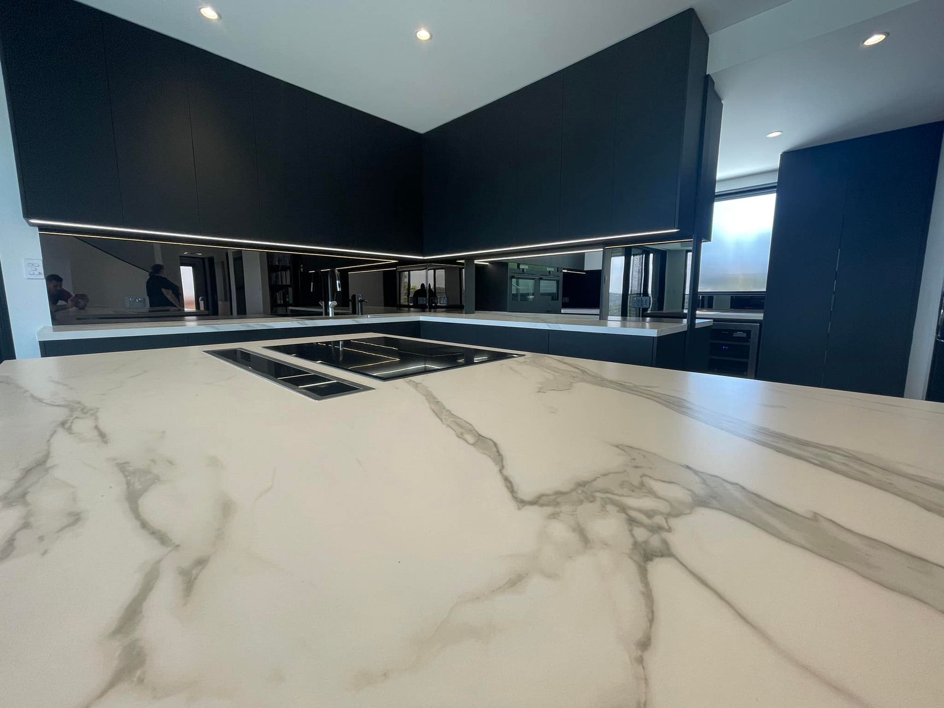 A Kitchen With a Marble Counter Top and Black Cabinets — PKJ Designs in Thirroul, NSW
