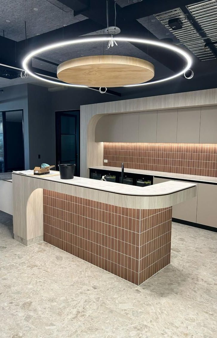 A Tiled Island Kitchen Bench With A Large Downlight — PKJ Designs in Unanderra, NSW