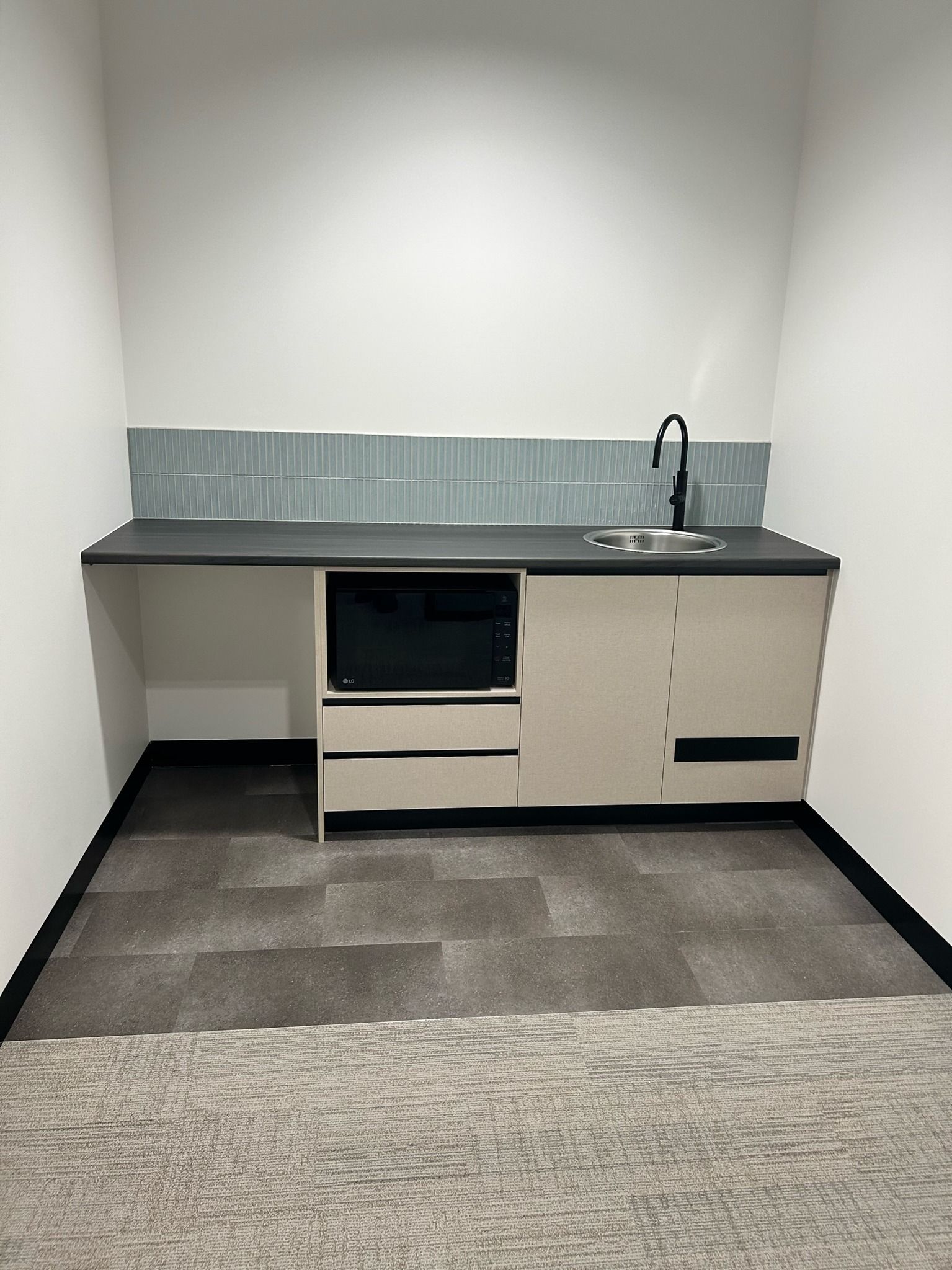 A Small Kitchen With a Sink, Microwave, and Cabinets — PKJ Designs in Unanderra, NSW