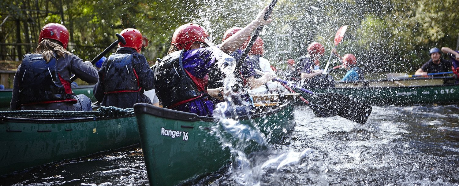 Scouts canoeing down a river