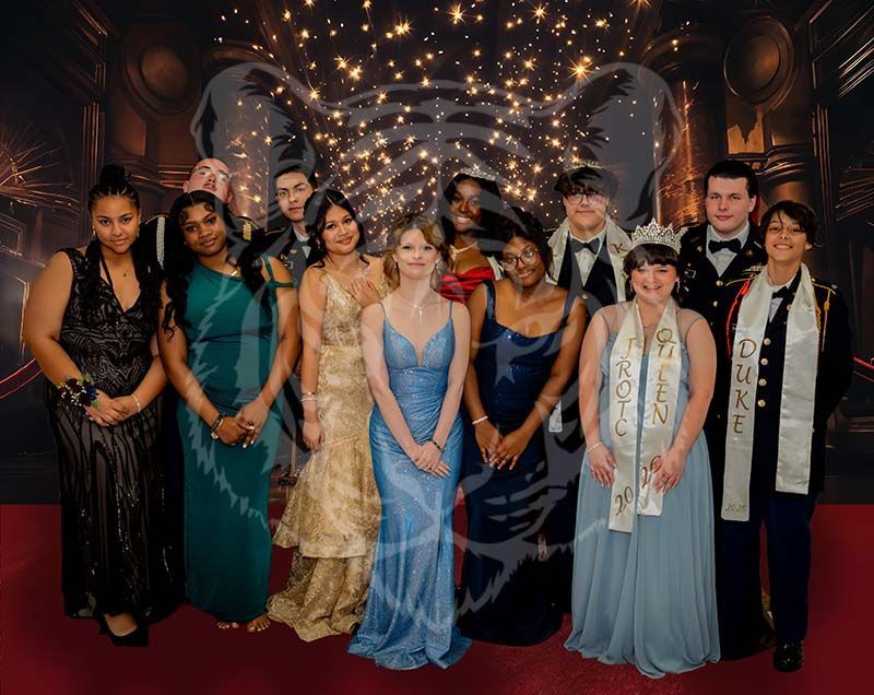 A group of eleven people in formal attire pose together on a red carpet in front of a decorative gold and black backdrop.
