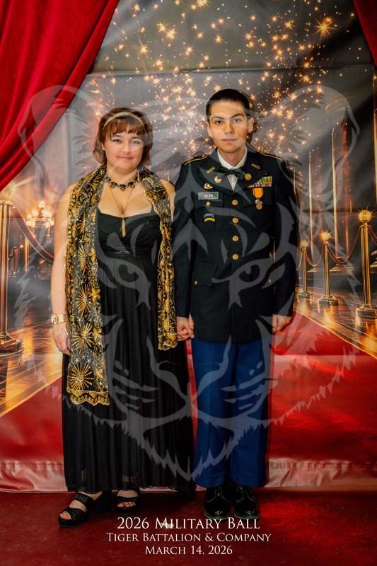 A formal portrait of two people posing together at the 2026 Tiger Battalion Military Ball with a red carpet background.