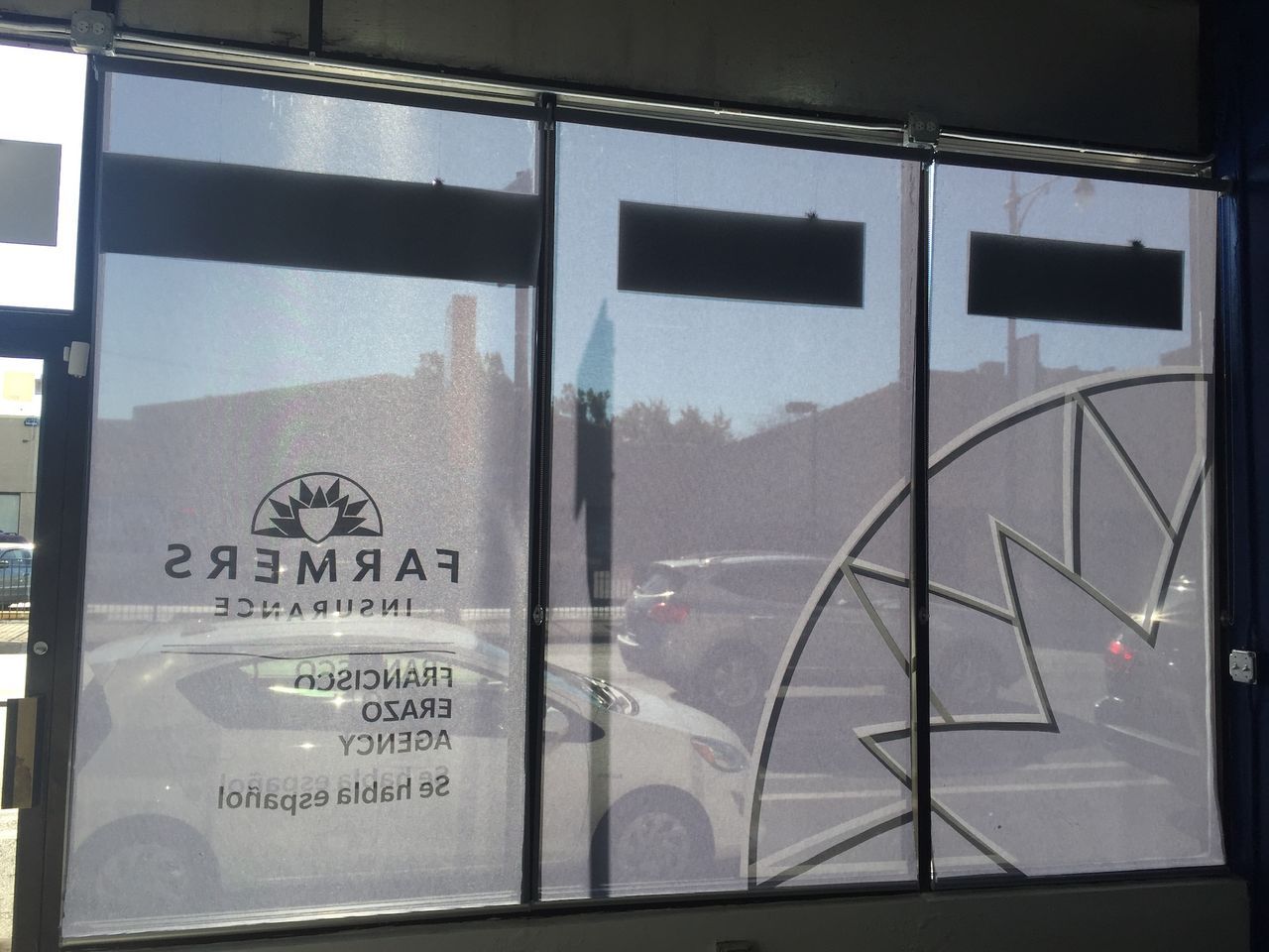 Storefront window with Farmers Insurance logo and white starburst graphic on frosted glass.