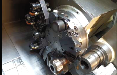 Industrial machine spindle with multiple cutting tools in a metal workshop