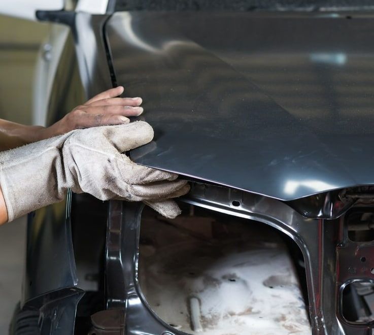 A Person Is Holding The Hood Of A Car — Spray Tech Smash Repairs In Gympie, QLD