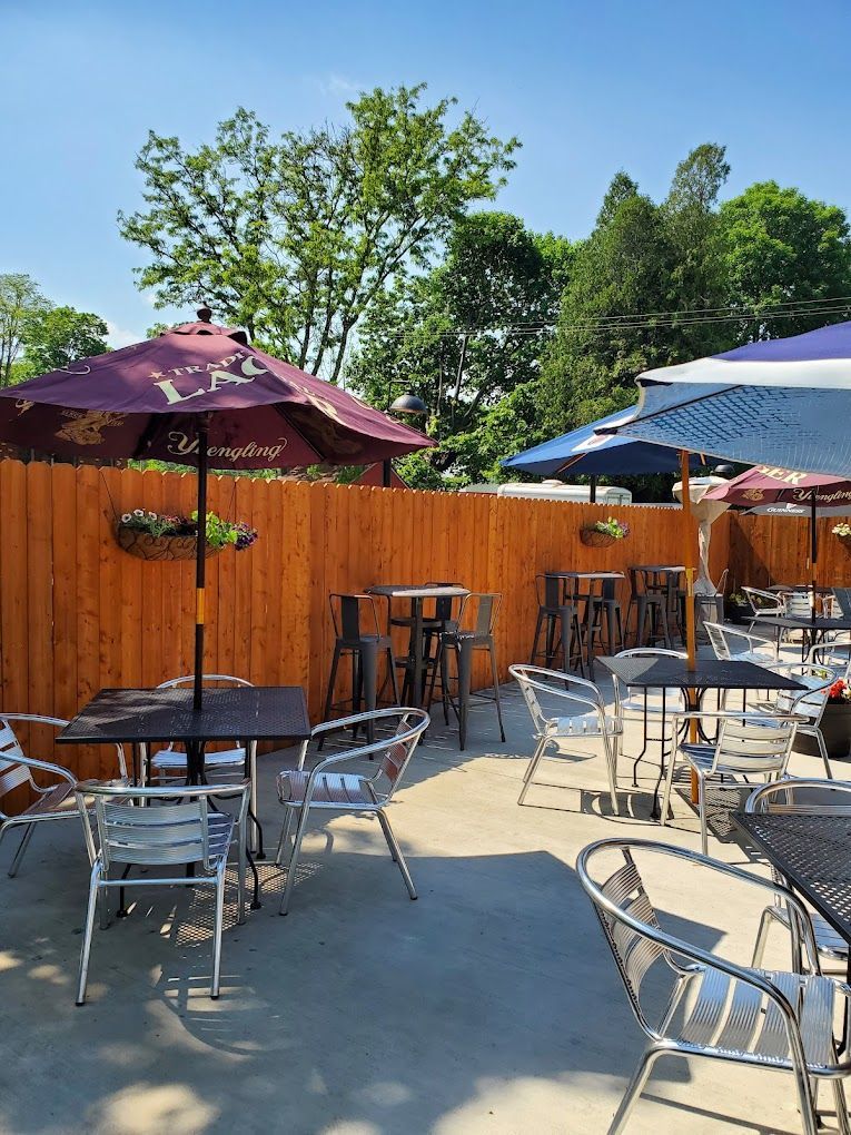 A patio with tables and chairs and umbrellas on a sunny day.