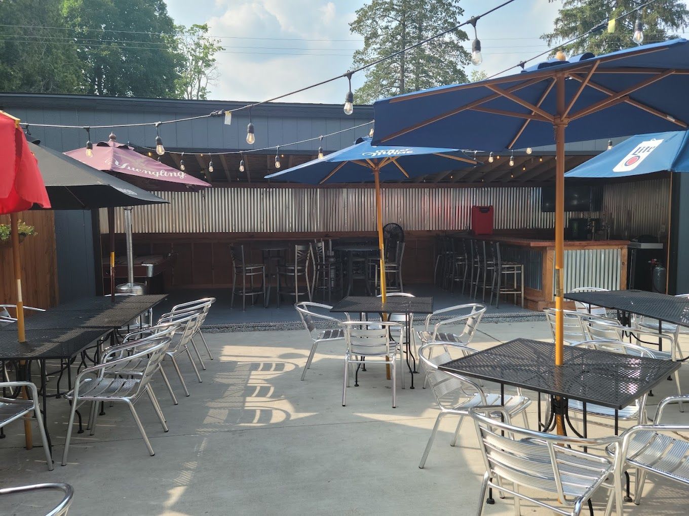 A restaurant with tables and chairs on a wooden deck.