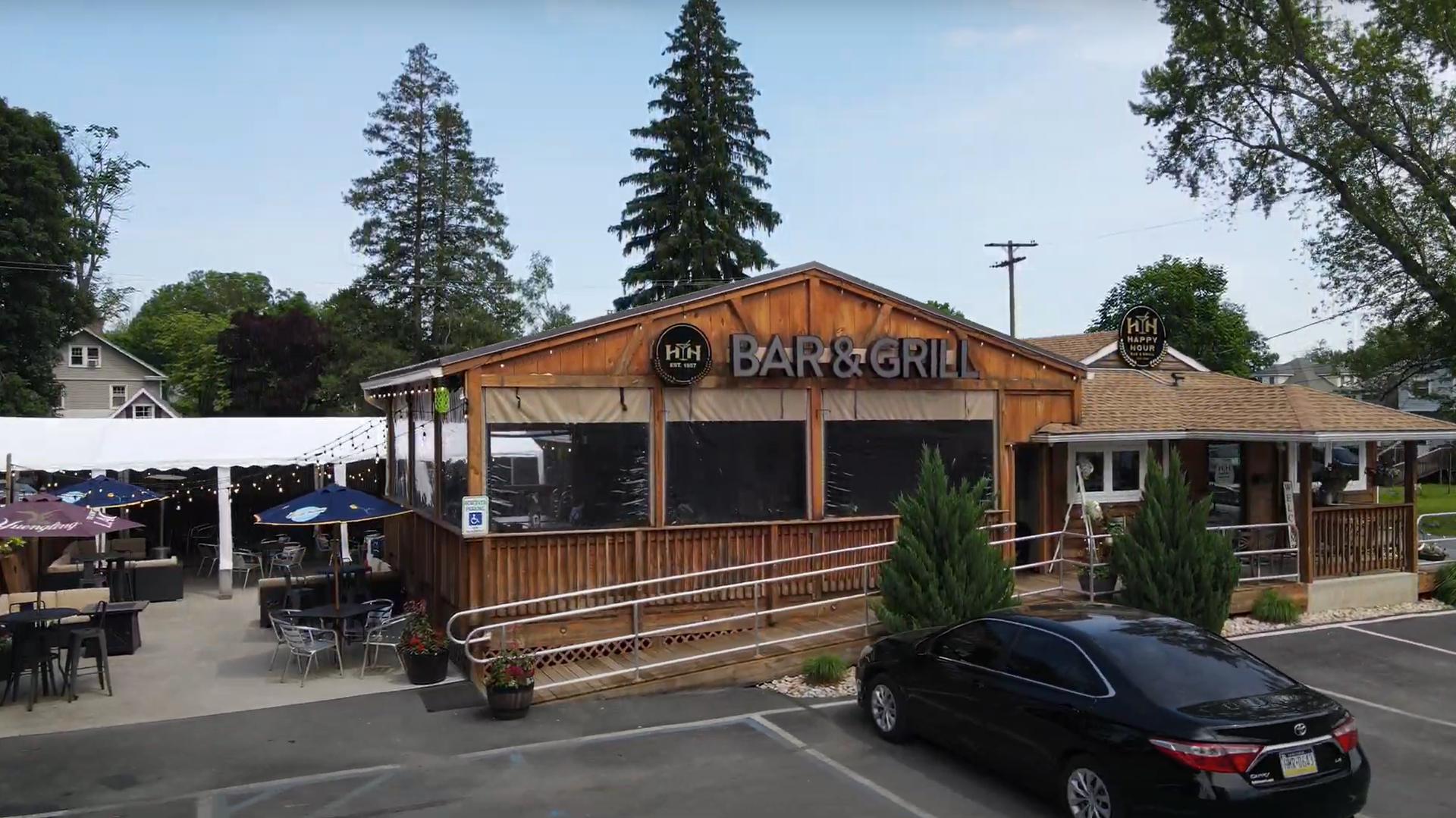 A restaurant with tables and chairs on a wooden deck.