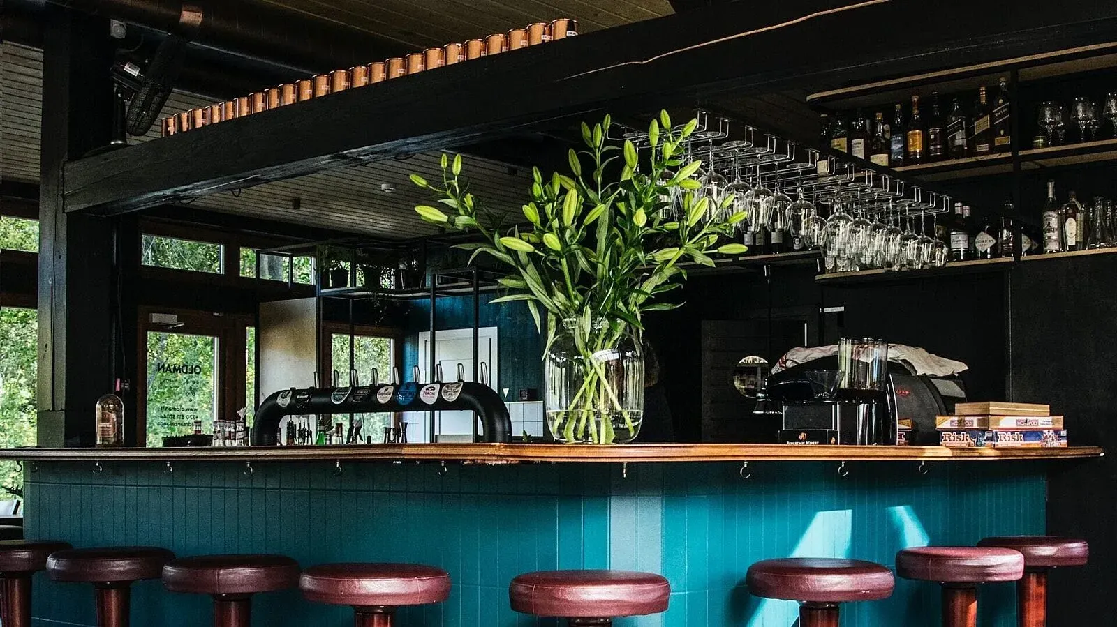 A bar with a vase of flowers on top of it A bar with a vase of flowers on top of it