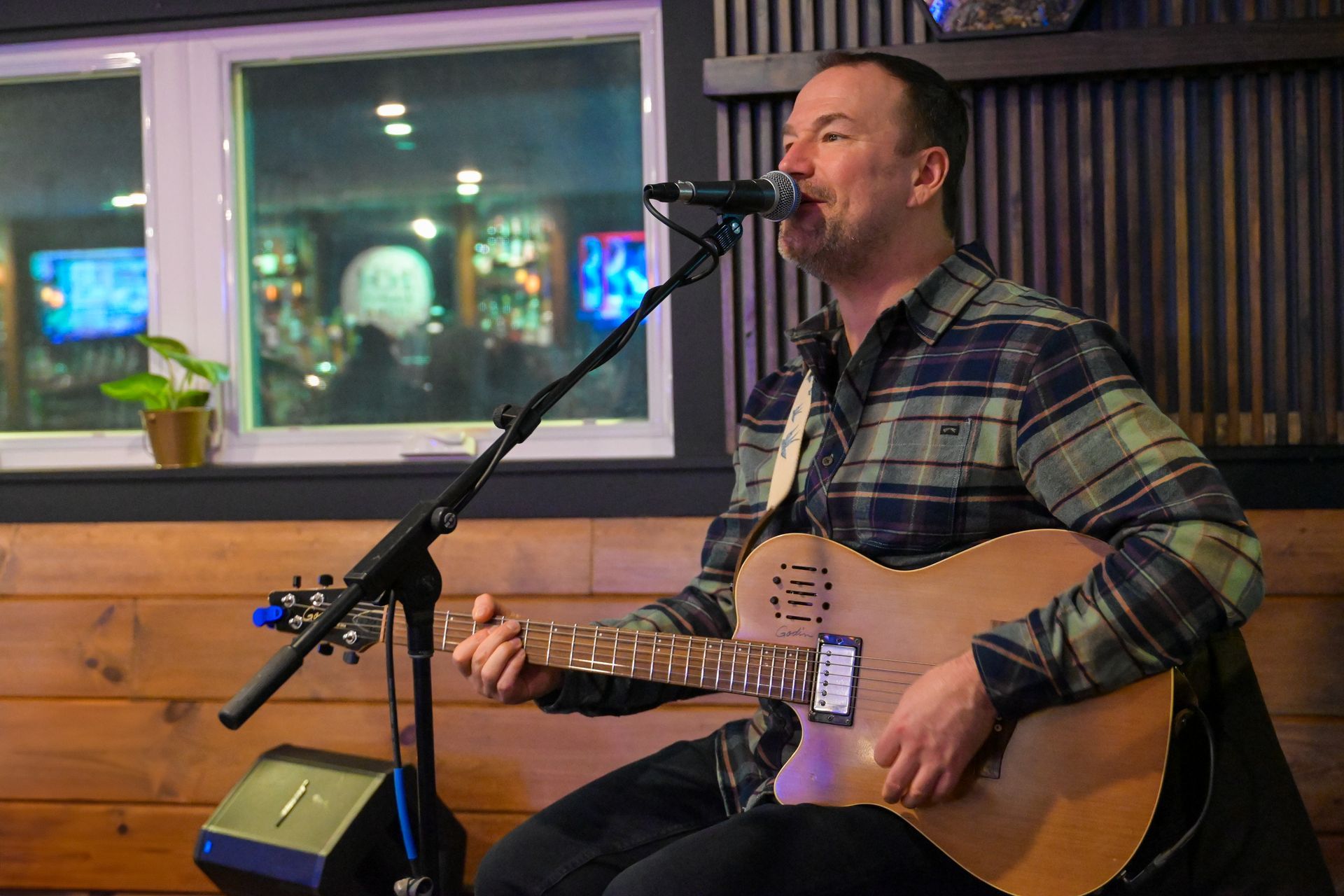 A man is playing a guitar and singing into a microphone.