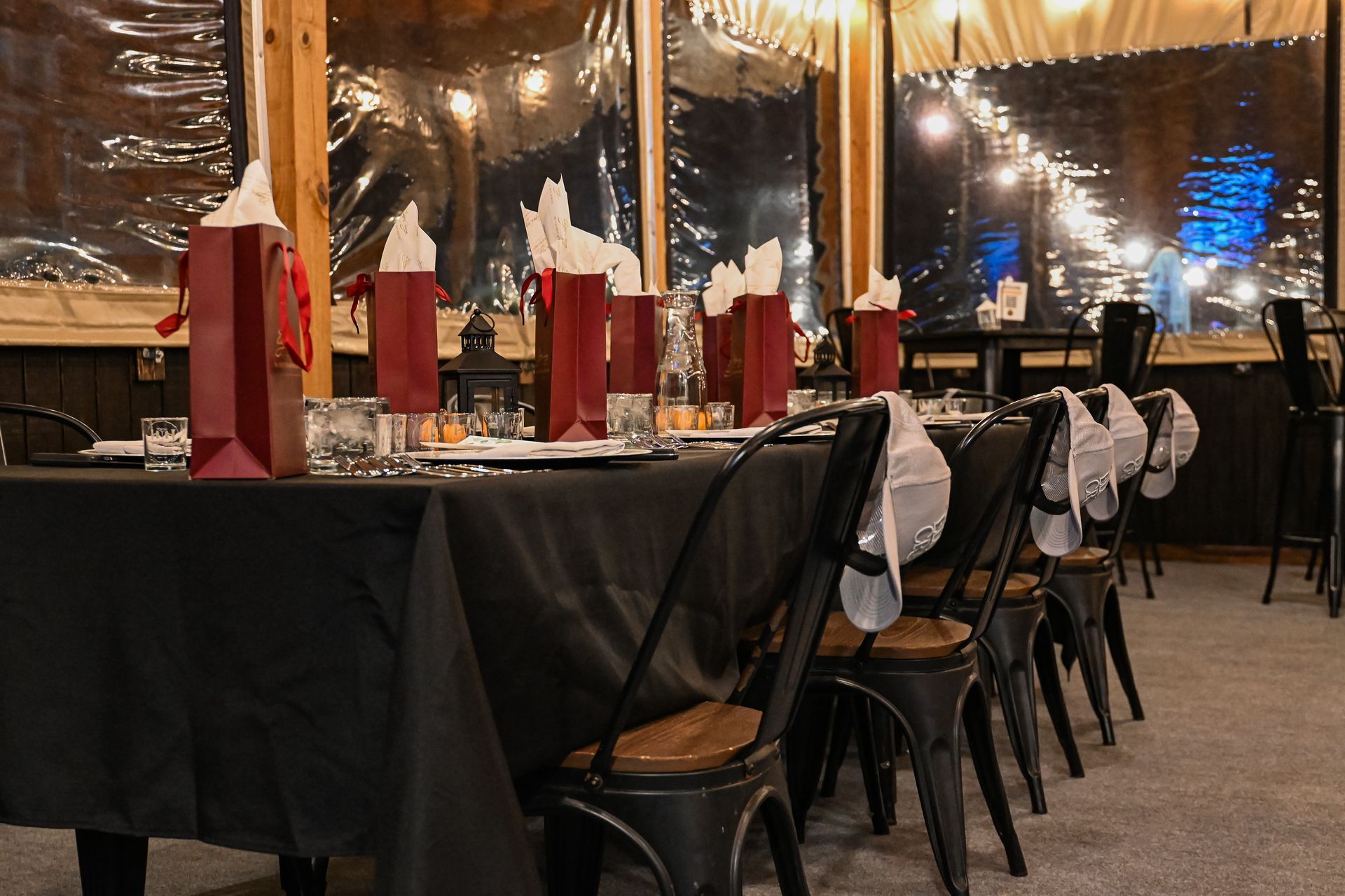 A long table with a black table cloth and chairs